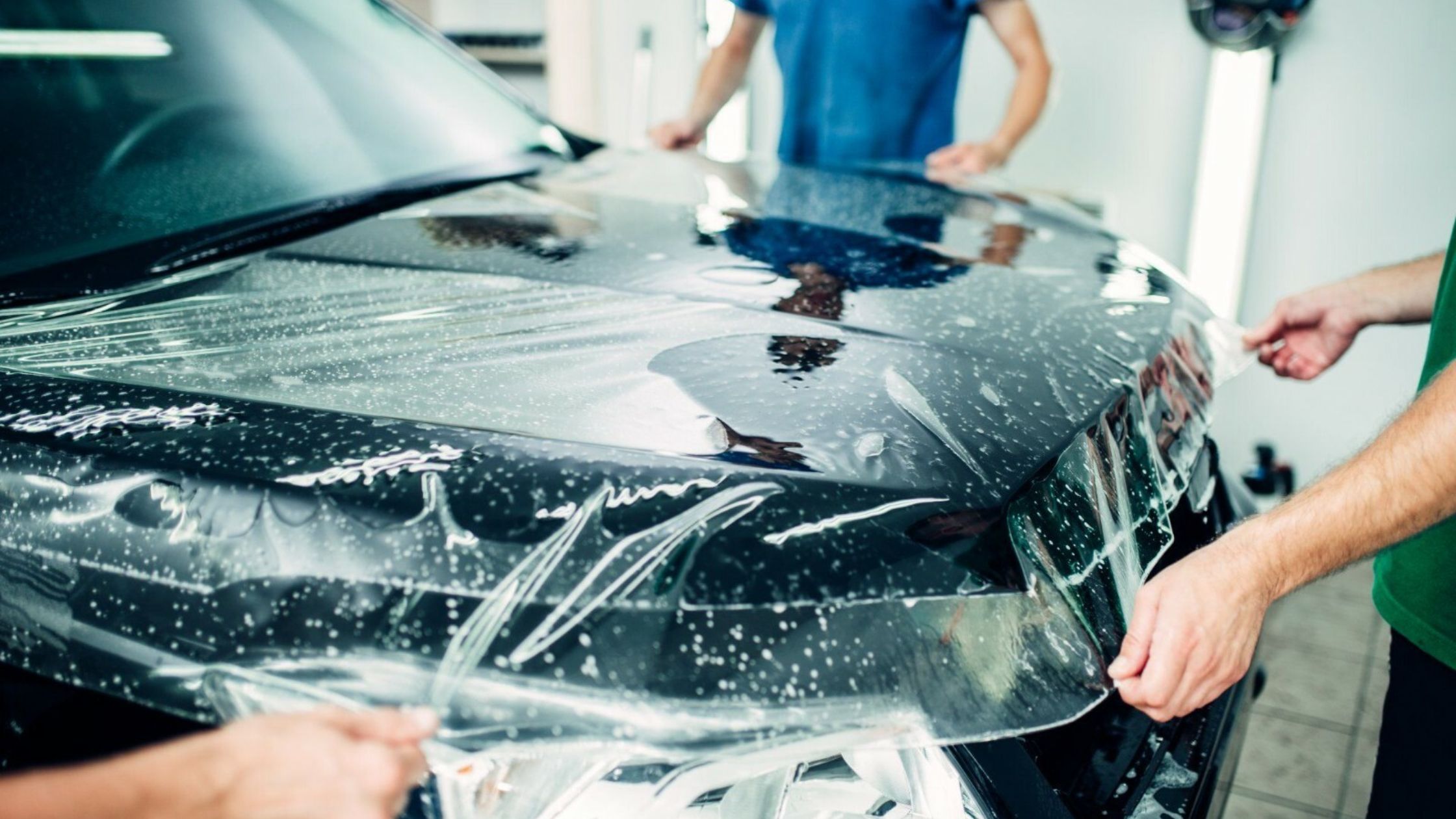 IX Exotics technician applying paint protection film on a vehicle